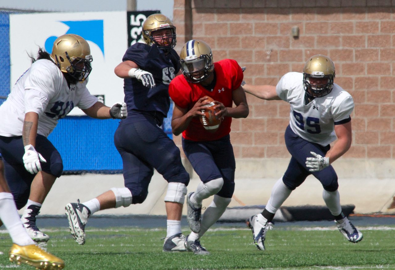 MSU quarterback Chris Murray (8) in the open field with defensive lineman Fou Polataivao (90) & Derek Marks (95) in pursuit