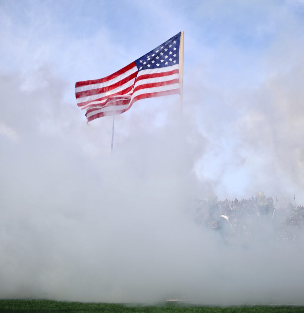 American flag through the smoke at Washington Grizzly Stadium