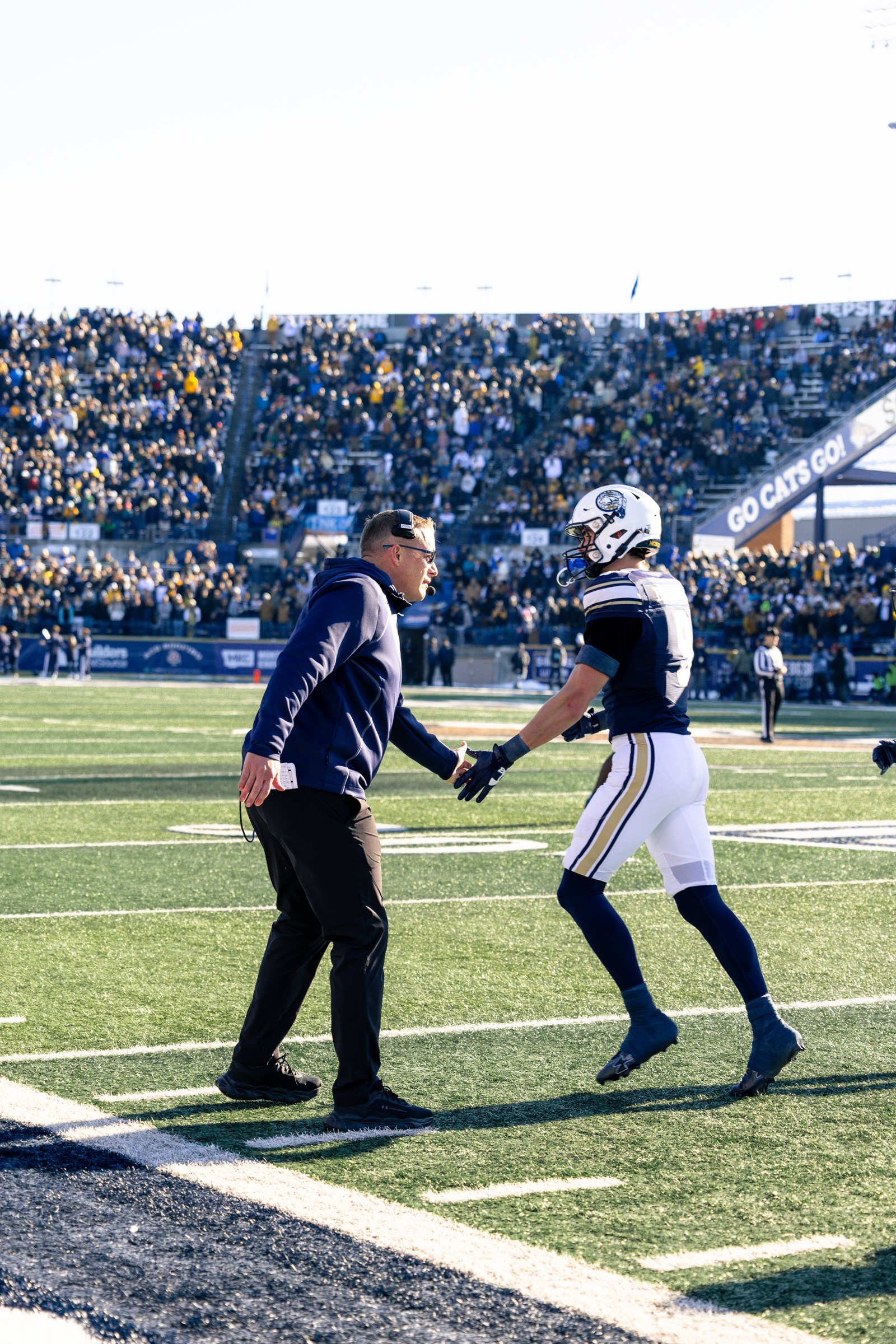 Brent Vigen greets a Bobcat on the sideline