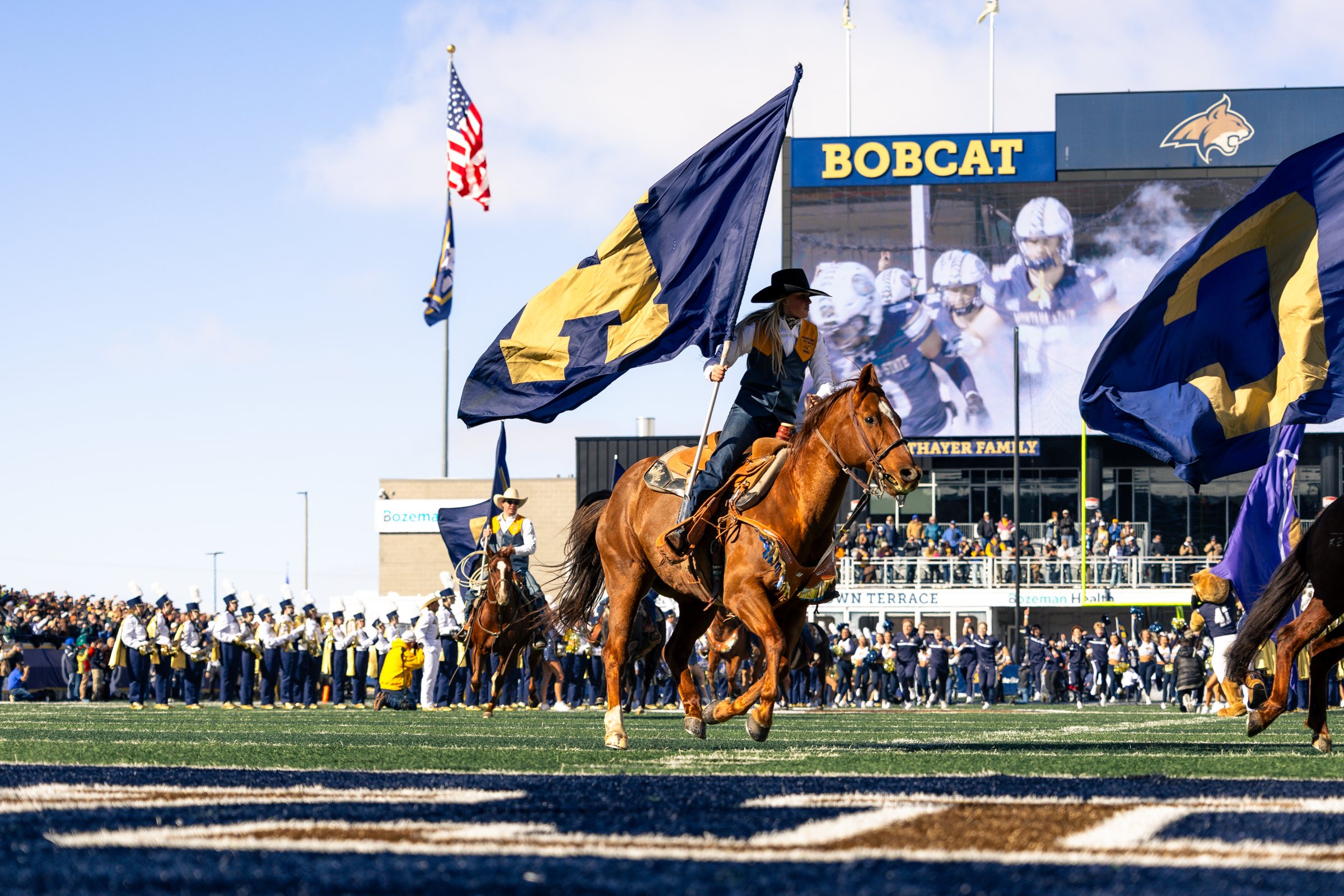 A Bobcat rider gallops the flag across the end zone