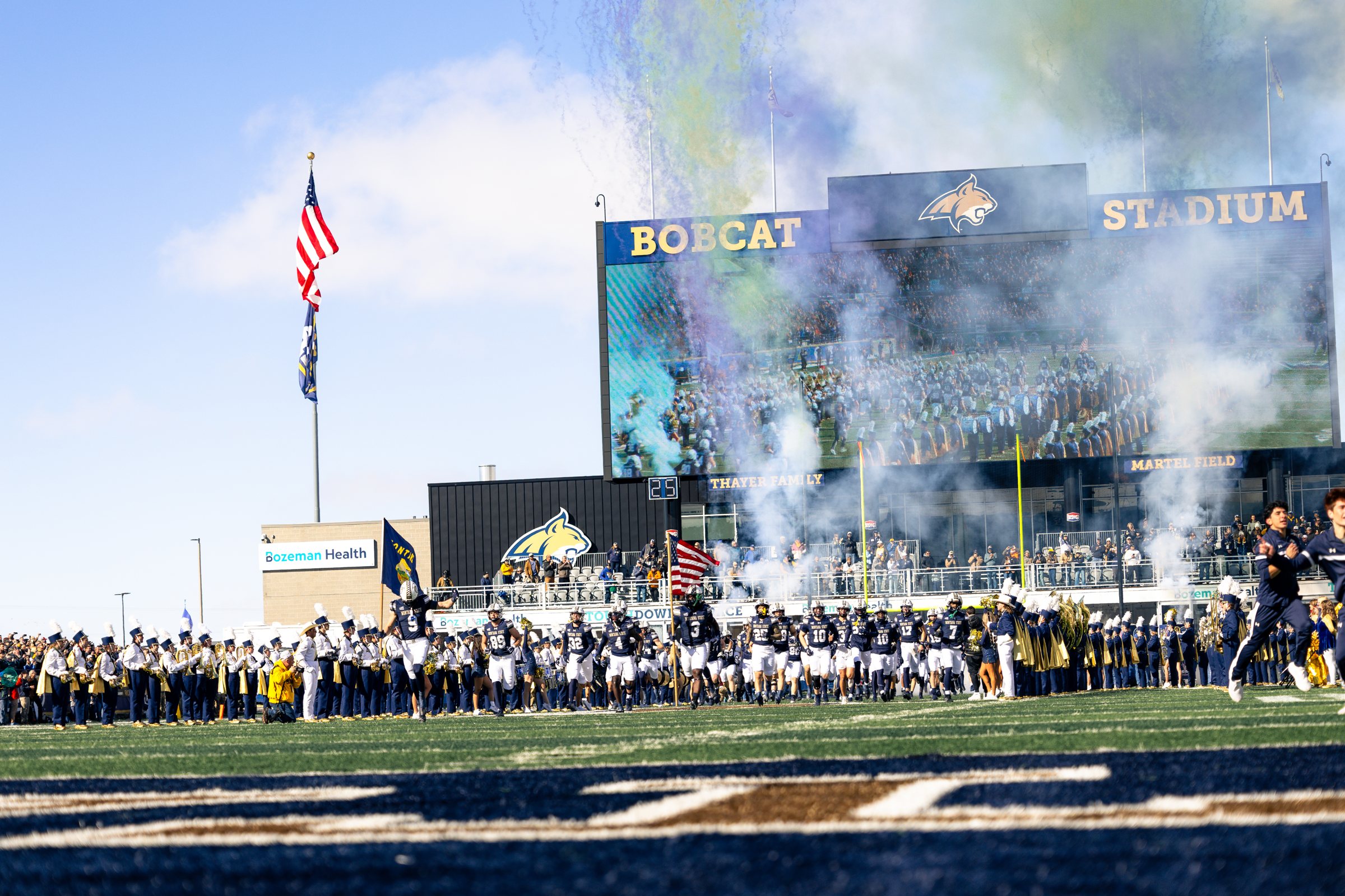The Bobcats take the field through the smoke