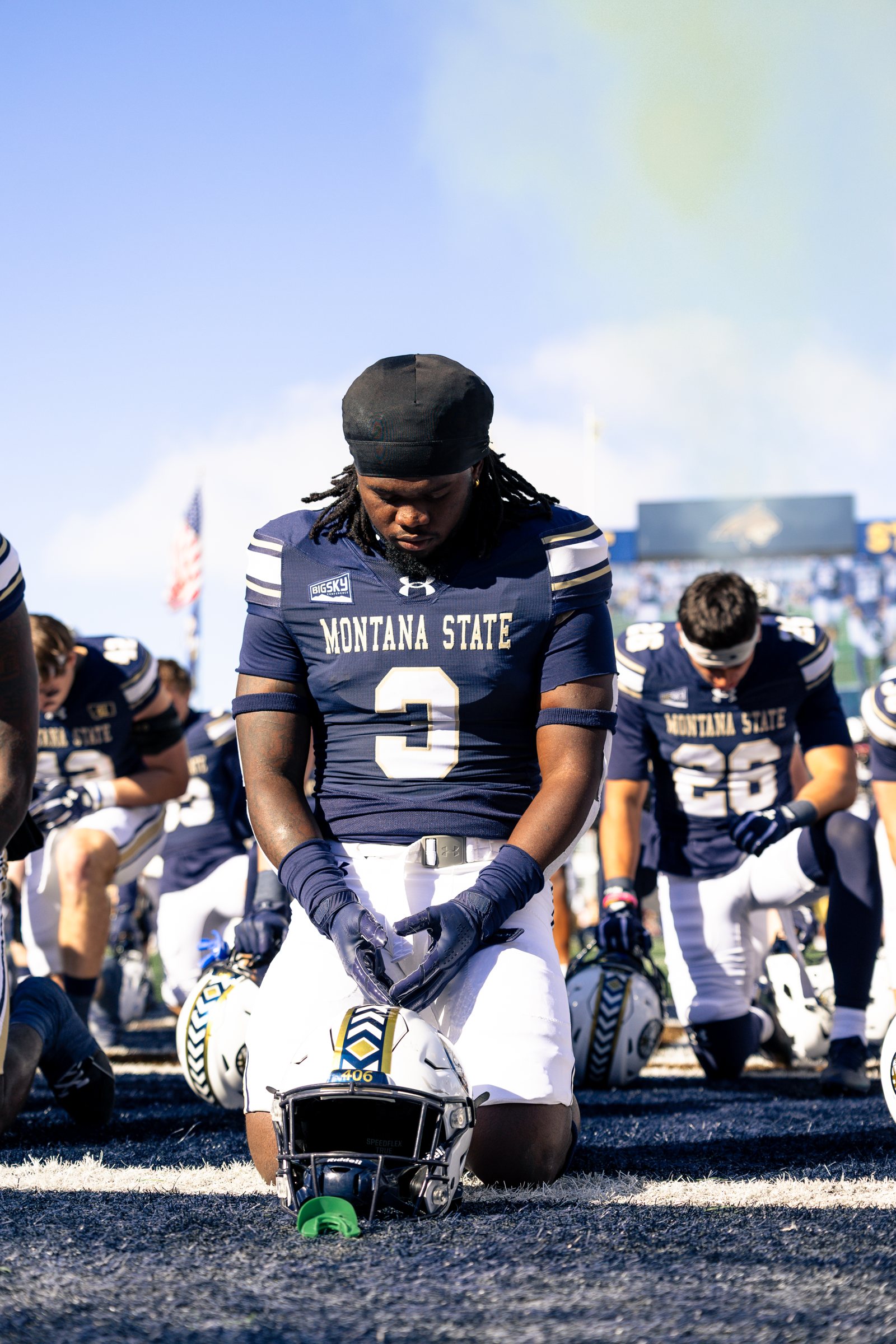 Jared White kneels in prayer before kickoff