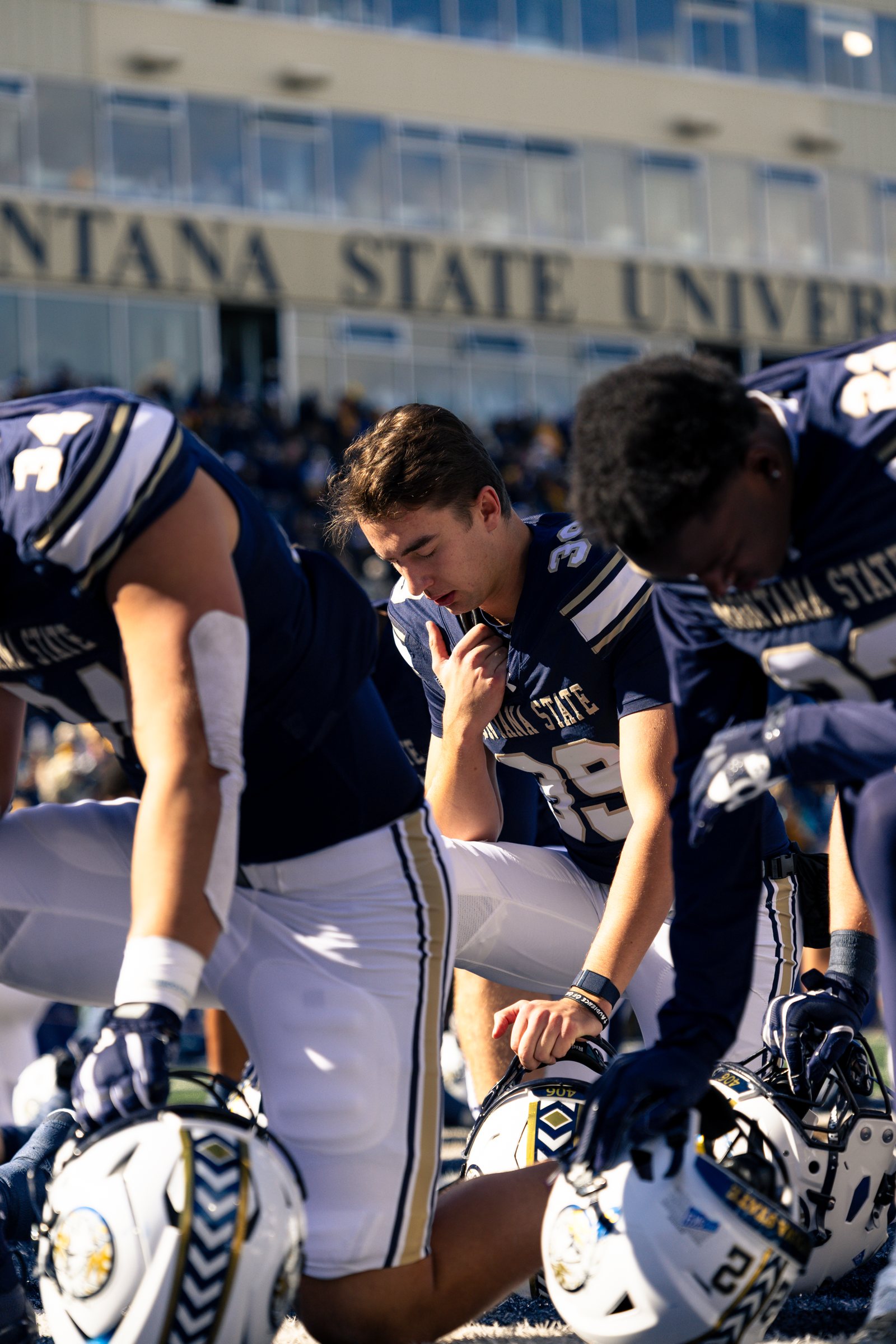 Bobcats kneel in prayer before kickoff